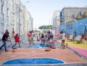 Adultos e crianças pintam rua em residencial em região vulnerável