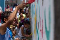 Criança participa de intervenção para qualificar espaço público no Jardim Lapena, na zona leste de São Paulo.