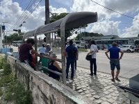 pessoas paradas em um ponto de ônibus