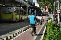 Homem andando de bicicleta em ciclofaixa.