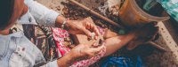 Foto ilustra mulher indígena manuseando castanhas