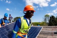 Homem negro faz instalação de placas solares