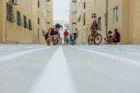 pessoas pintam o chão entre prédios