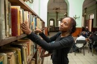 mulher olhando para livros em uma biblioteca