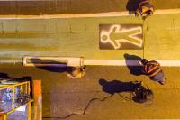 imagem de homens pintando faixa de pedestres no chão de rua