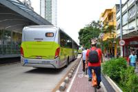 imagem mostra homem em ciclovia e ônibus na pista ao lado