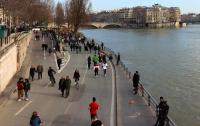ciclistas e pedestres às margens do rio sena em paris