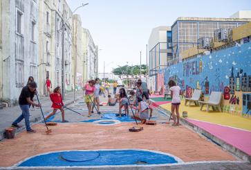 Adultos e crianças pintam rua em residencial em região vulnerável