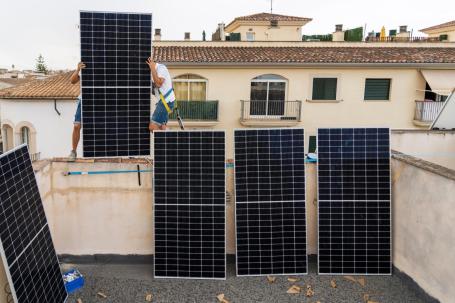 Pessoas instalam painéis solares em edifício na Espanha