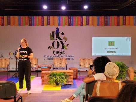 Imagem mostra mulher palestrando em evento da COP30