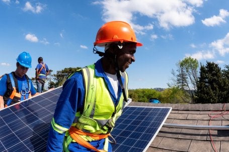 Homem negro faz instalação de placas solares