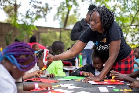 A agente de ligação da biblioteca Orpah Anyango Agunda ajuda alunos do Art Bunk na Biblioteca Eastlands 