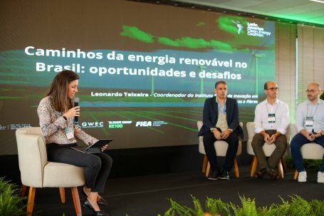 Pessoas no palco em frente a um telão