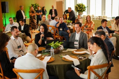 Grupo sentado à mesa em reunião