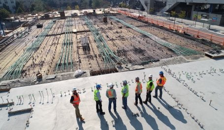 trabalhadores da construção civil no topo de uma estrutura 