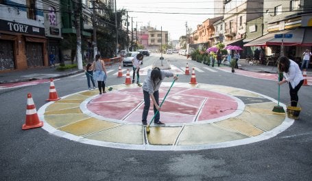 pessoas pintam rotatória