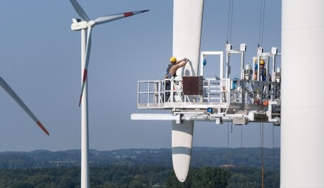 homem faz manutenção em turbina eólica