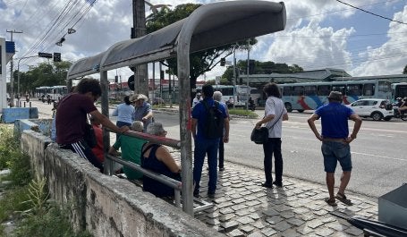 pessoas paradas em um ponto de ônibus