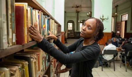 mulher olhando para livros em uma biblioteca