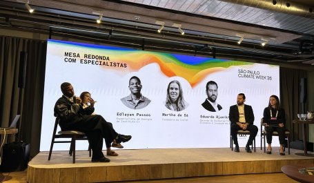 quatro pessoas no palco em frente a um telão na São Paulo Climate Week