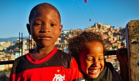 Dois pequenos moradores do Complexo do Alemão. A comunidade, antes com acesso a pé ou por transportes informais, conta agora com um teleférico que a conecta até terminais de transportes e serviços básicos, garantindo acesso a empregos e a saúde e educação a seus residentes. (Foto: Clément Jacquard/Flickr).