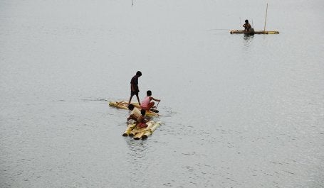 crianças navegando em enchente