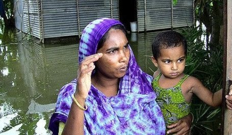 Mãe e filho em uma casa alagada em Bangladesh (foto: Shawn/Flickr)