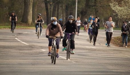 pessoas andando de bicicleta com máscaras covid-19