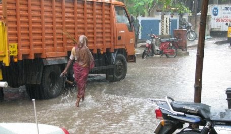 imagem de alagamento em Chennai na índia mostra uma pessoa caminhando em uma rua alagada