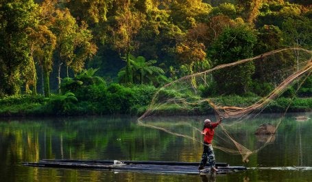 imagem de pescador lançando tarrafa na indonésia 