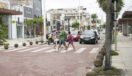 pessoas atravessam rua em faixa de segurança elevada