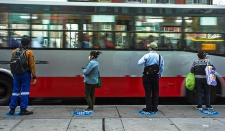 foto de pessoas de máscara esperando ônibus