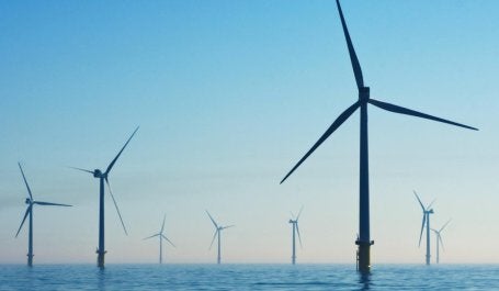 cata ventos de energia eólica com pôr do sol ao fundo