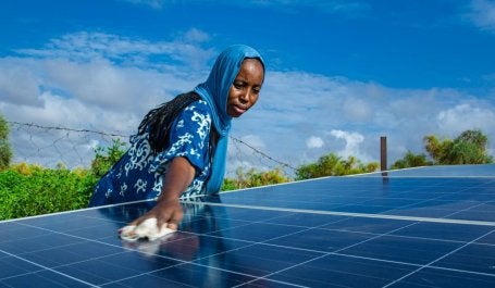 Mulher limpa um painel solar na Mauritânia