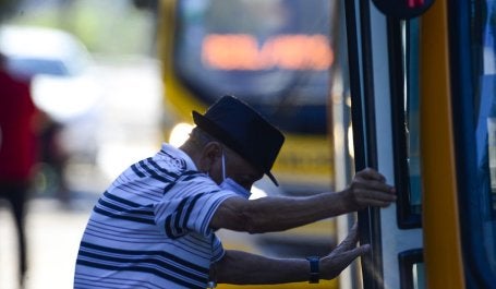 homem de máscara embarca em ônibus