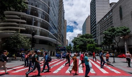 pessoas atravessando a rua em faixa de segurança
