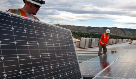 homens trabalham em painel solar