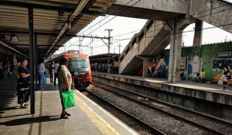 mulher espera por metrô de superfície que se aproxima