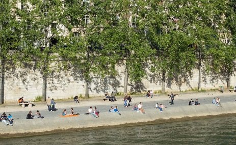 Pessoas descansam às margens do rio Sena, em Paris. A França está entre os países que têm avançado na elaboração de estratégias de longo prazo que alinham metas climáticas e de desenvolvimento para proteger as comunidades e fortalecer a resiliência. (Foto: mrstam/iStock) 