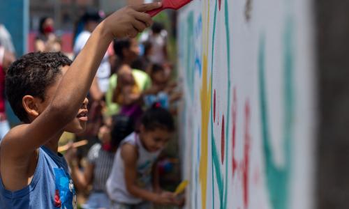 Criança participa de intervenção para qualificar espaço público no Jardim Lapena, na zona leste de São Paulo.