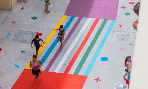 crianças correndo em rua colorida