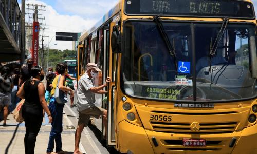 pessoas usando máscara sobem em ônibus coletivo em Salvador