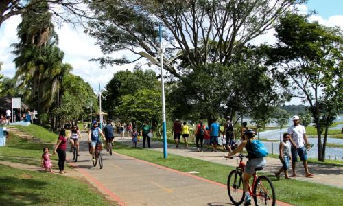 parque com ciclovia e pessoas caminhando e pedalando