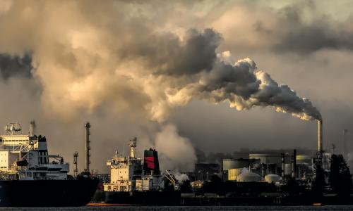 imagem de navio e fábrica soltando fumaça poluente