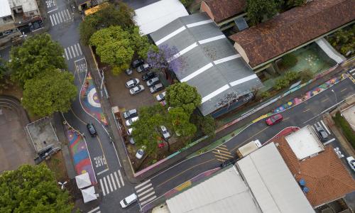 vista aérea de zona 30 em entorno escolar. O asfalto foi pintado para promover comportamento mais seguro de motoristas e espaço para pedestres.